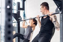 Père et fille utilisant pull up bar dans la salle de gym — Photo de stock