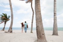 Jeune couple marchant sur la plage tropicale — Photo de stock