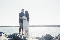 Casal em pé na rocha costeira, face a face, Seal Beach, Califórnia, EUA — Fotografia de Stock