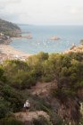 Donna in piedi sulla roccia, guardando la vista, vista elevata, Tossa de mar, Catalogna, Spagna — Foto stock