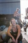Grupo de pessoas se exercitando no ginásio, mulher sentada em primeiro plano — Fotografia de Stock
