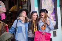 Friends leaving clothing shop smiling — Stock Photo