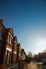 Vista di case marroni sulla strada contro il cielo blu — Foto stock