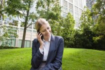 Young businesswoman talking on cellphone outdoors — Stock Photo