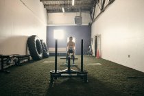 Frau im Fitnessstudio mit Trainingsgeräten — Stockfoto