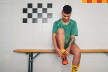 Fußballerinnen binden Schnürsenkel auf Bank in Umkleidekabine — Stockfoto