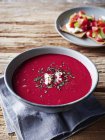 Close up of bowl of tasty homemade borscht soup on wooden table — Stock Photo