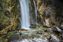 Caminhante olhando para cachoeira em montanhas amaldiçoadas, Theth, Shkoder, Albânia, Europa — Fotografia de Stock