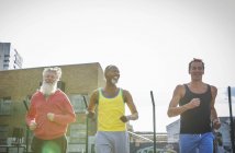 Three mature men jogging outdoors — Stock Photo