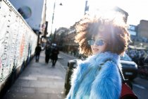 Retrato de mulher com cabelo afro vestindo casaco de pele olhando para a câmera — Fotografia de Stock