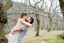 Романтическая пара целуется и обнимается в парке — стоковое фото