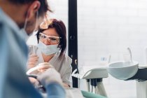 Dentiste et infirmière dentaire, examinant la bouche du patient — Photo de stock