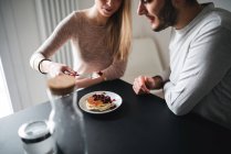 Cropped view of couple eating pancakes — Stock Photo