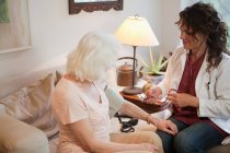 Medico che prende la pressione sanguigna della donna anziana — Foto stock