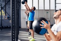Group of people in gym using medicine balls — Stock Photo