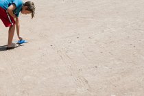 Ragazzo che gioca con aeroplano giocattolo sul pavimento — Foto stock