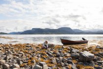 Boy playing amongst rocks by fjord, Aure, More og Romsdal, Norway — Stock Photo