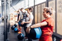 Group of people in gym using medicine balls — Stock Photo