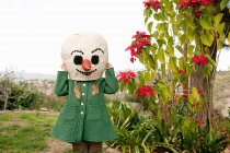 Ragazza in cappotto verde e pupazzo di neve testa di marionetta — Foto stock
