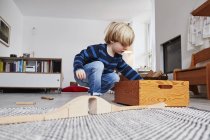 Giovane ragazzo che gioca con i giocattoli in soggiorno — Foto stock