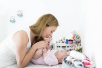 Madre jugando con el bebé en el cambiador - foto de stock