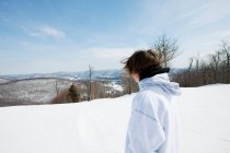 Junger Mann blickt auf verschneite Landschaft — Stockfoto