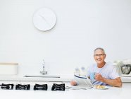 Seniorchef frühstückt und liest Zeitung — Stockfoto