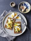 Still life of rye crackers with boiled sliced eggs on plate — Stock Photo