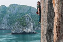 Man rock climbing on limestone rock, Ha Long Bay, Vietnam — Stock Photo