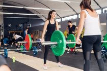 Frauen-Gewichtheben mit Langhanteln im Fitnessstudio — Stockfoto