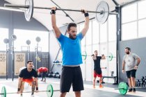 Mann beim Gewichtheben Langhantel in Turnhalle — Stockfoto