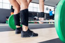 Cropped view of woman weightlifting barbell in gym — Stock Photo
