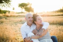 Портрет пары, обнимающейся в поле — стоковое фото