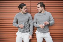 Jovens gêmeos do sexo masculino fazendo pausa de treinamento — Fotografia de Stock