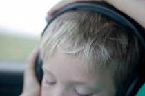 Primer plano del niño con auriculares - foto de stock