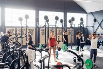 Groupe de personnes haltérophilie en salle de gym — Photo de stock