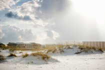 Blick auf Sanddünen und Häuser gegen wolkenverhangenen Himmel — Stockfoto