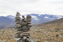 Cairn de piedra en el paisaje de montaña, Parque Nacional Jotunheimen, Lom, Oppland, Noruega - foto de stock
