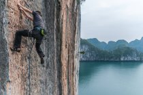 Homme escalade sur rocher calcaire, Ha Long Bay, Vietnam — Photo de stock