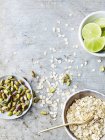 Top view of pistachios, oats and lime on wooden table — Stock Photo