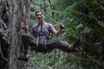 Front view of male rock climber hanging on ropes, Squamish, Canada — Stock Photo