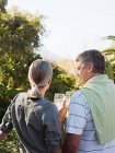 Couple with glasses of wine looking at view from garden — Stock Photo