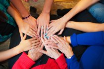Cropped image of multicultural women putting hands together — Stock Photo