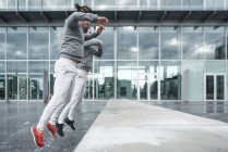 Молоді чоловіки-близнюки тренуються і стрибають в стіну в місті — стокове фото