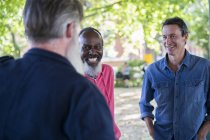 Трое взрослых мужчин разговаривают на улице — стоковое фото