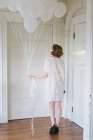 Mulher no apartamento segurando um monte de balões — Fotografia de Stock