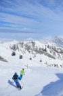 Veduta posteriore di padre e figlio che sciano in pista, Hintertux, Tirolo, Austria — Foto stock