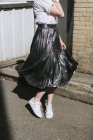 Low section view of Woman in street twirling metallic skirt — Stock Photo