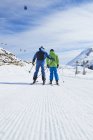 Veduta posteriore di padre e figlio in vacanza sugli sci, Hintertux, Tirolo, Austria — Foto stock
