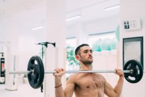 Man weightlifting using barbell in gym — Stock Photo